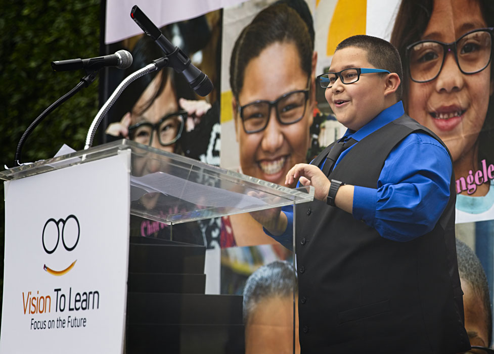 Santiago, a fifth grader in Los Angeles, tells the crowd how glasses have helped him