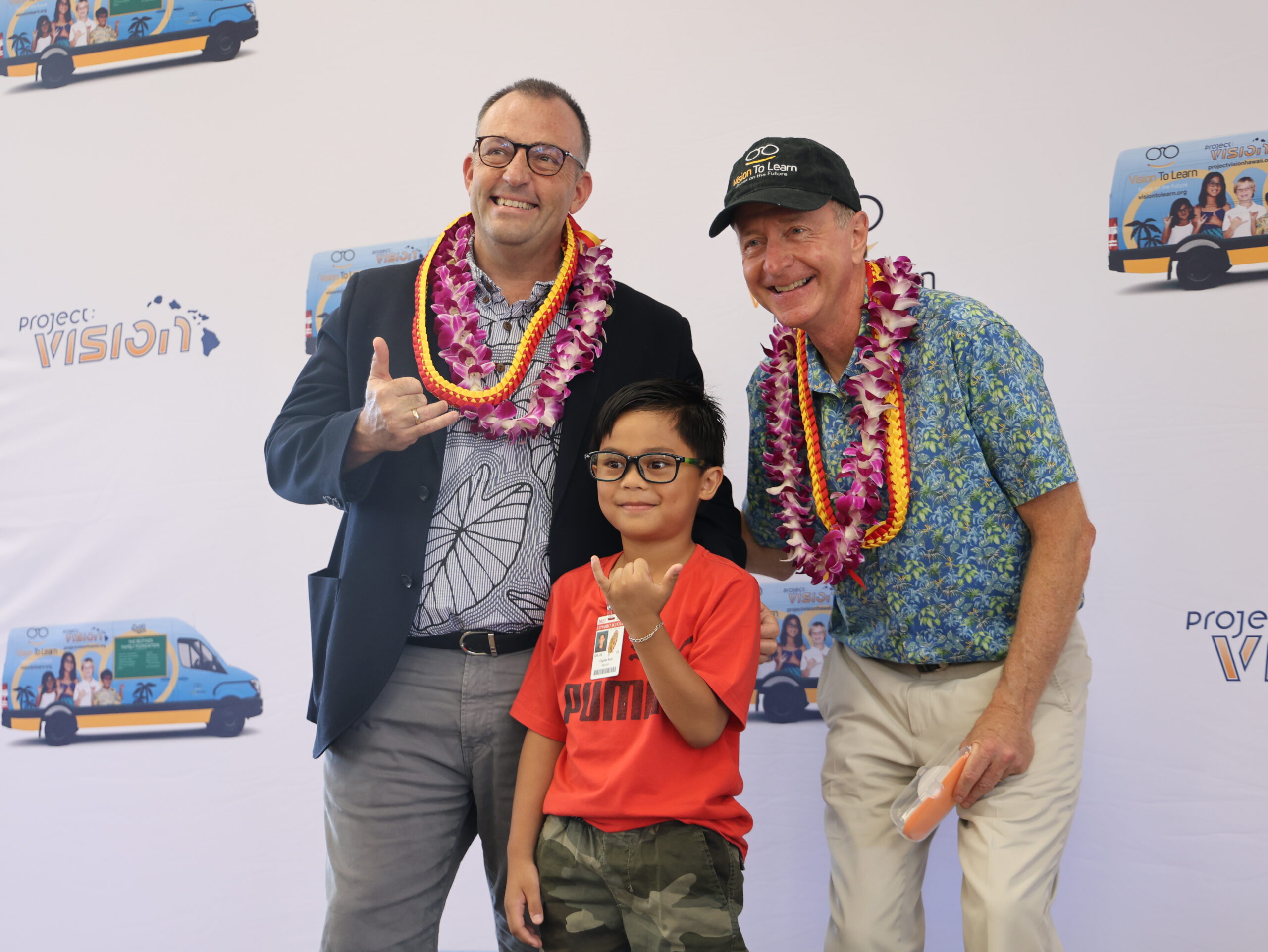 Governor Josh Green and Vision To Learn founder Austin Beutner pose for a picture with a 4th grade student from King William C. Lunalilo Elementary.