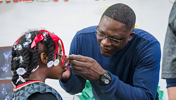 Dominique Wilkins helping student in Atlanta with new glasses