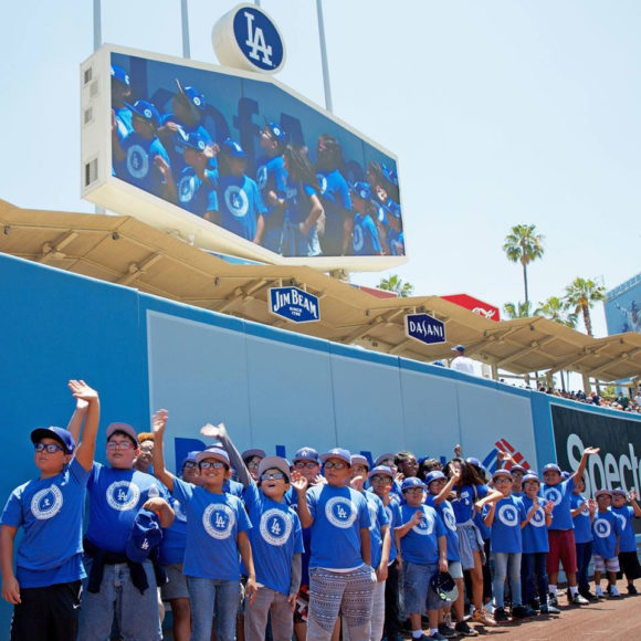 L.A.-area students wave from the outfield as the Dodgers host them at Dodgers Stadium for some summer fun
