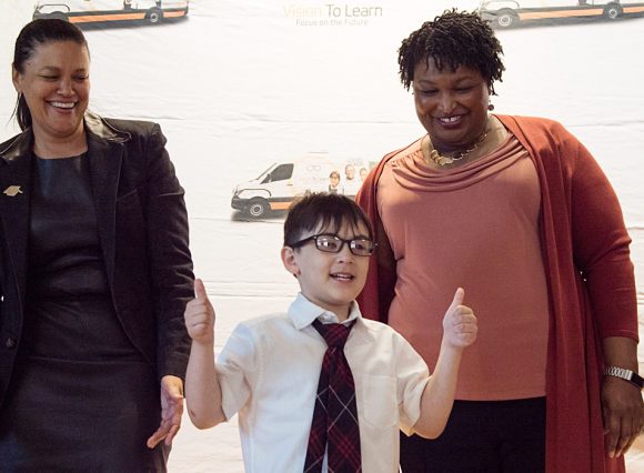 Thumbs up, indeed! Atlanta Public Schools Superintendent Dr. Meria Carstarphen and Former Georgia House Minority Leader Stacey Abrams flank a Barack and Michelle Obama Academy student who just received his new glasses.