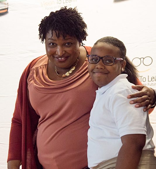 Nothing but smiles as Former Georgia House Minority Leader Stacey Abrams takes a moment with a Barack and Michelle Obama Academy student who just received her new glasses.
