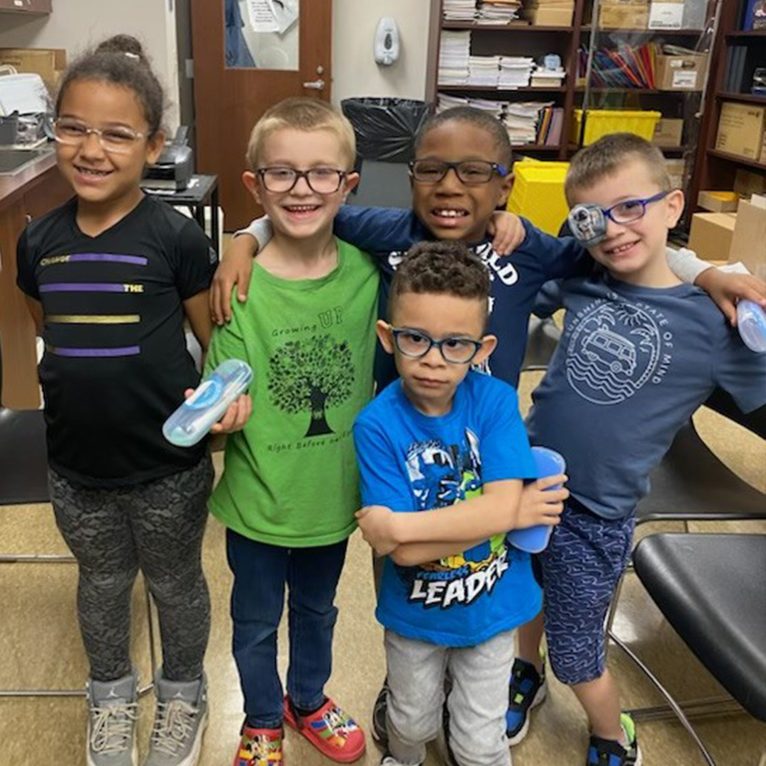 A group of five elementary school students pose for a picture in the middle of the school nurse's office.