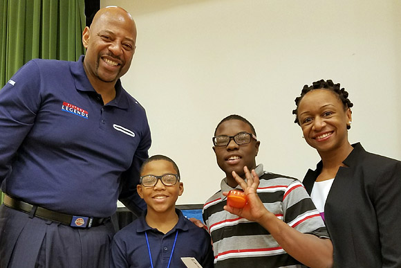 NBA legend Earl Cureton and Dr. Joneigh S. Khaldun, Executive Director of the Detroit Health Department, help kids receive their new glasses at Ronald Brown Academy in Detroit, February 2017.