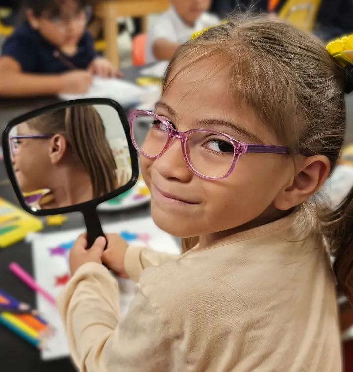 Girl with new glasses and mirror