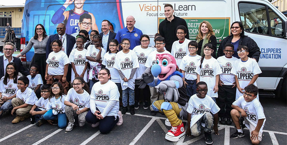 Group shot of kids with news glasses in front of the mobile clinic