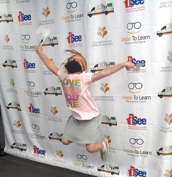 child jumps for joy with new glasses